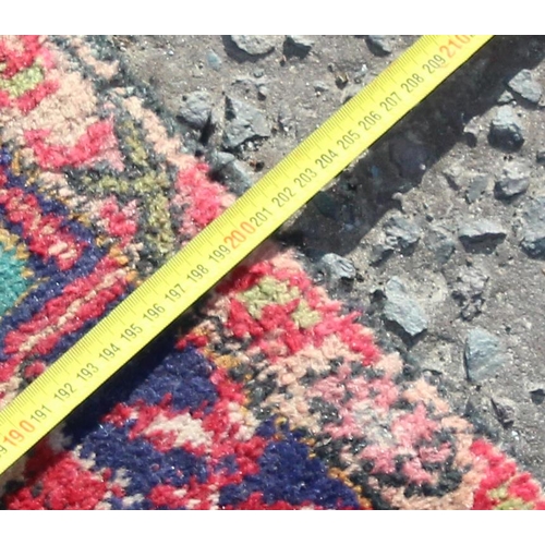 203 - A large vintage Persian handmade rug of red & blue ground with palmette border, approx 292cm x 200cm... 