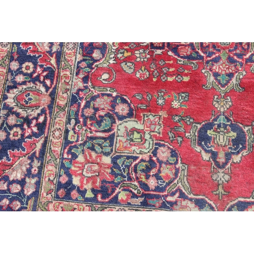 203 - A large vintage Persian handmade rug of red & blue ground with palmette border, approx 292cm x 200cm... 