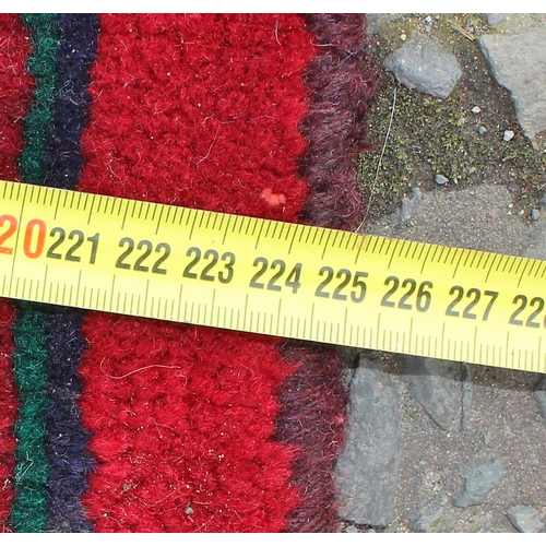 207 - A large decorative Iranian rug of red ground decorated with various geometric patterns, approx 309cm... 