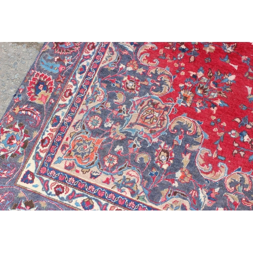 208 - A large decorative Persian rug of red ground with Herati border, approx 362cm x 271cm, label verso