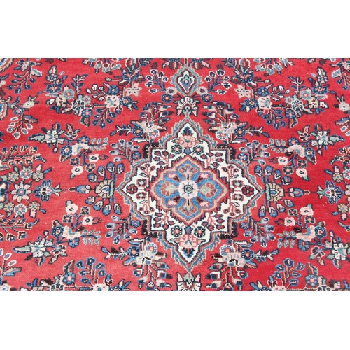 209 - A large decorative Iranian rug of red ground with geometric border, approx 313cm x 200cm, label vers... 