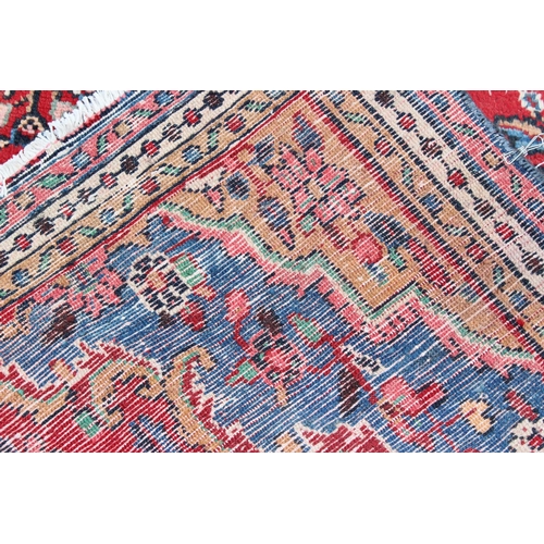 209 - A large decorative Iranian rug of red ground with geometric border, approx 313cm x 200cm, label vers... 