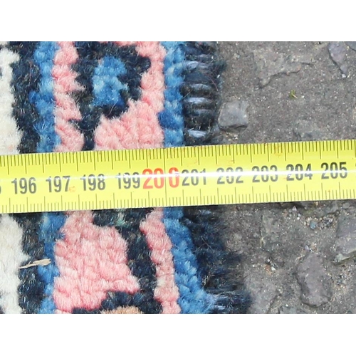 209 - A large decorative Iranian rug of red ground with geometric border, approx 313cm x 200cm, label vers... 