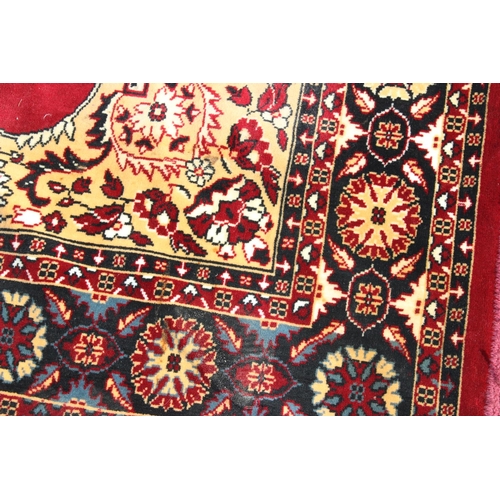 210 - A decorative red ground rug with central medallion, approx 190cm x 137cm