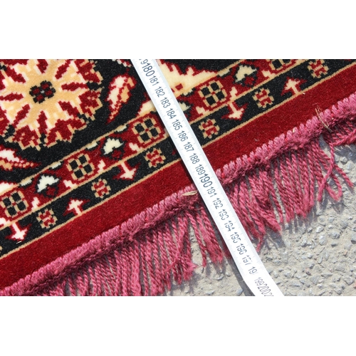 210 - A decorative red ground rug with central medallion, approx 190cm x 137cm