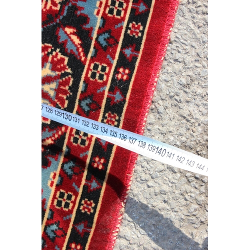 210 - A decorative red ground rug with central medallion, approx 190cm x 137cm