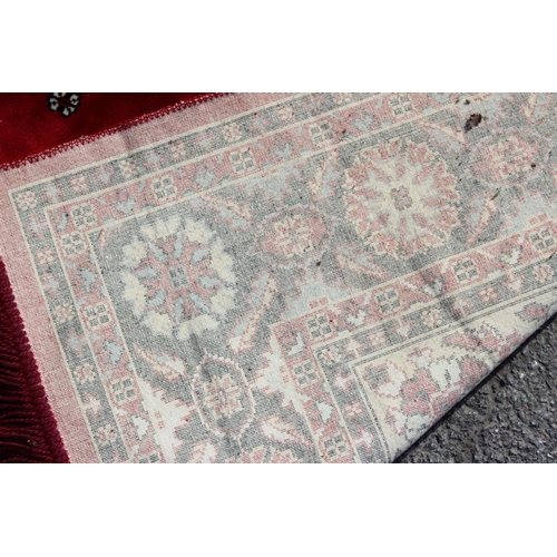 210 - A decorative red ground rug with central medallion, approx 190cm x 137cm