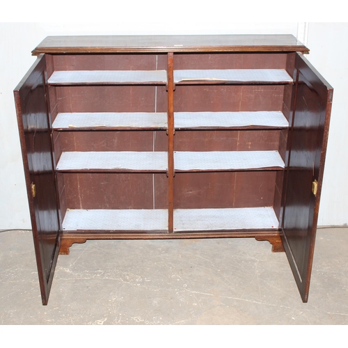 77 - A large antique Mahogany cupboard standing on bracket feet, with key