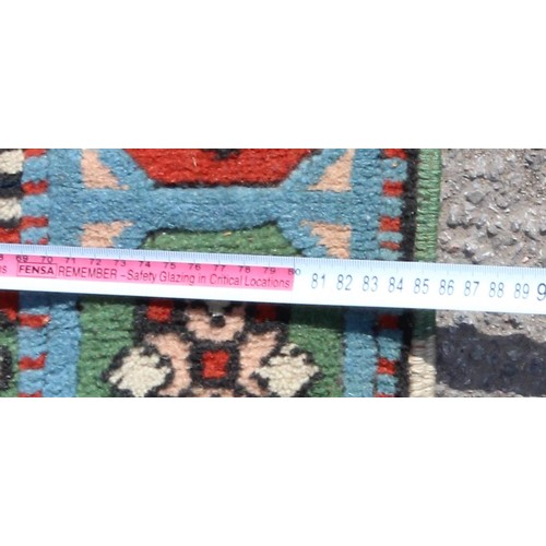 215 - An unusual vintage handmade rug with 3 medallions on cream ground, approx 136cm x 85cm