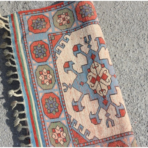 215 - An unusual vintage handmade rug with 3 medallions on cream ground, approx 136cm x 85cm