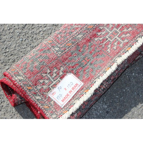 217 - A vintage Iranian made red ground rug decorated with 3 lines of 6 gul, approx 200cm x 124cm, label v... 