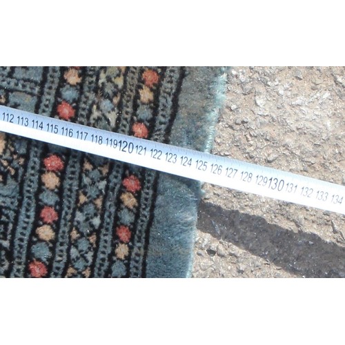 219 - A vintage blue ground rug decorated with gul, approx 194cm x 125cm