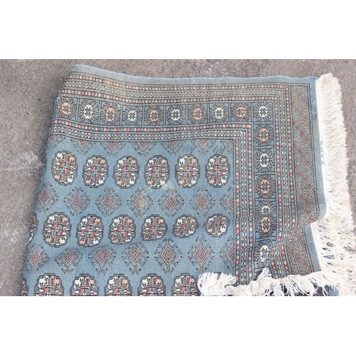 219 - A vintage blue ground rug decorated with gul, approx 194cm x 125cm