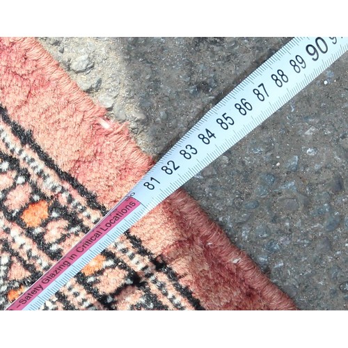 220 - A long vintage hall runner rug of red ground, decorated with gul, approx 525cm x 81cm