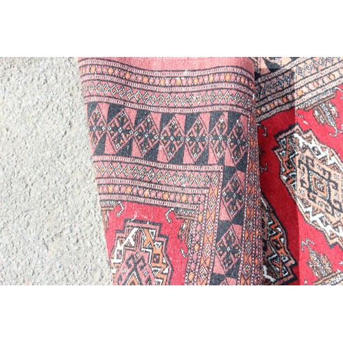 220 - A long vintage hall runner rug of red ground, decorated with gul, approx 525cm x 81cm