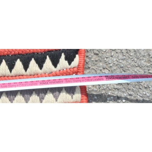 221 - An unusual flat weave rug of colourful geometric pattern