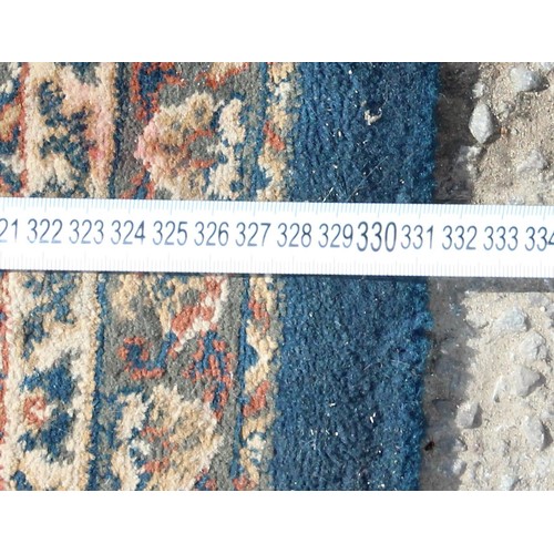 223 - A large blue ground rug with decorative Persian design
