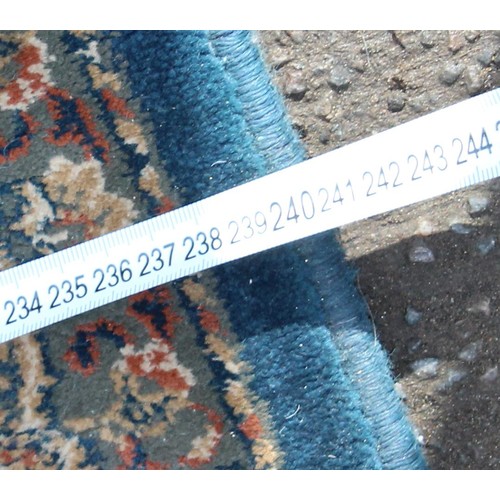 223 - A large blue ground rug with decorative Persian design