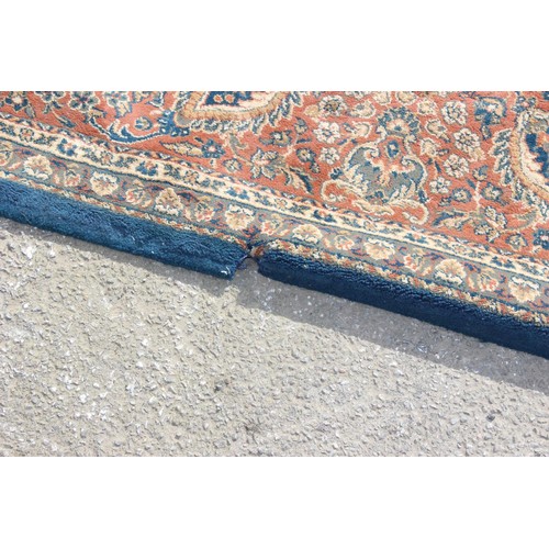 223 - A large blue ground rug with decorative Persian design