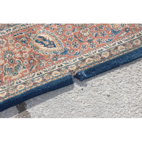 223 - A large blue ground rug with decorative Persian design