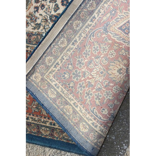 223 - A large blue ground rug with decorative Persian design