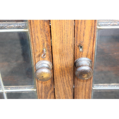 118 - A Jacobean style Oak glazed bookcase with leaded glass panels