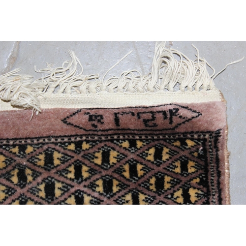 228 - A long runner rug decorated with various medallions and woven signature - believed to be of Pakistan... 