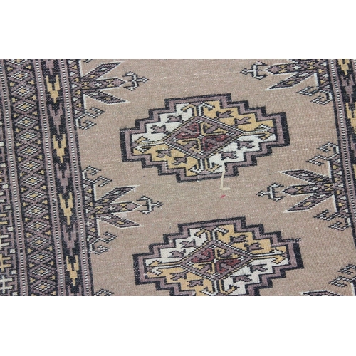 228 - A long runner rug decorated with various medallions and woven signature - believed to be of Pakistan... 