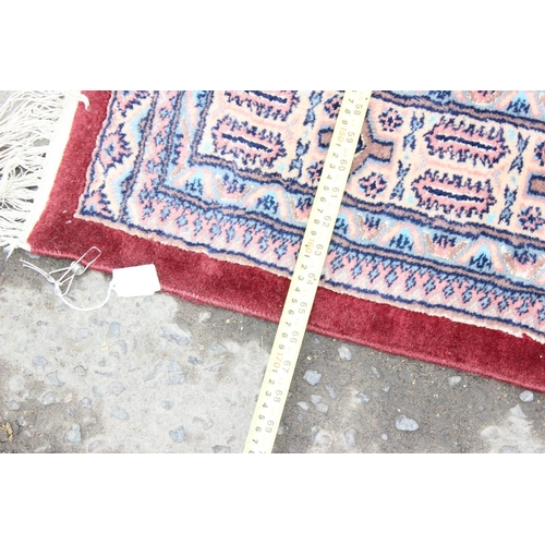 227 - A vintage red ground rug with 3 lines of 7 gul, approx 234cm x 167cm