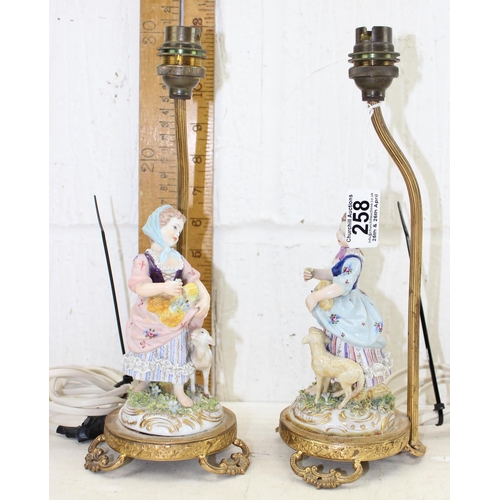 258 - A pair of porcelain figural table lamps formed as girls with sheep, with gilt metal mounts