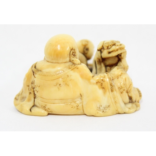 1603 - A Japanese carved netsuke depicting a seated male with 2 playing children, signed, approx 43mm wide