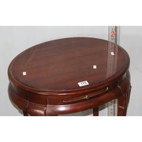 115 - A 20th century oval table with side stand