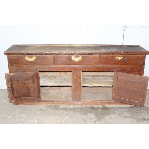 20 - A 19th century scumbled pine dresser base with 2 cupboards and 3 drawers, interesting advertising re... 