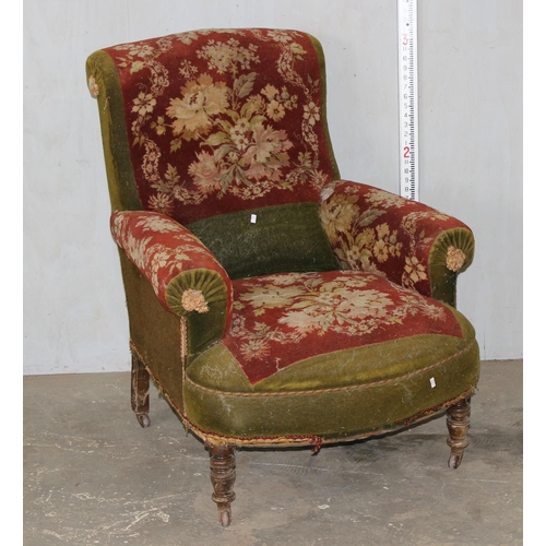 27 - An antique carpet upholstered deep seated armchair on turned wooden legs and metal and ceramic casto... 