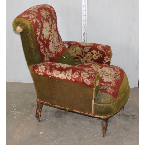 27 - An antique carpet upholstered deep seated armchair on turned wooden legs and metal and ceramic casto... 