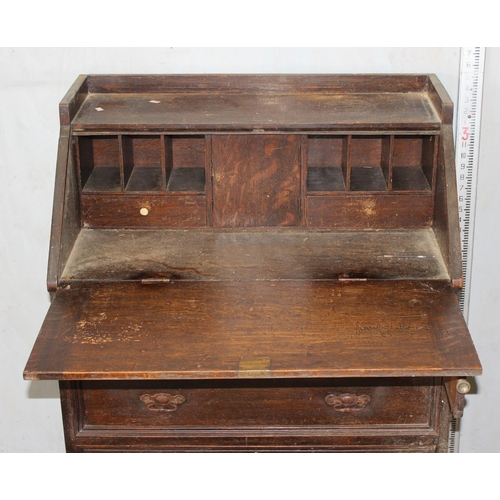 32 - An early 20th century oak bureau with interesting Art Nouveau strapwork handles