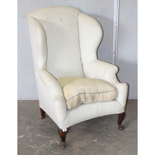 58 - A Georgian style wingback armchair with cream upholstery