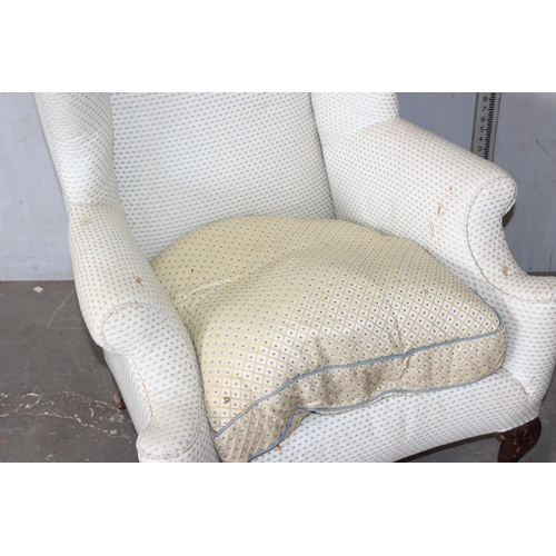 58 - A Georgian style wingback armchair with cream upholstery