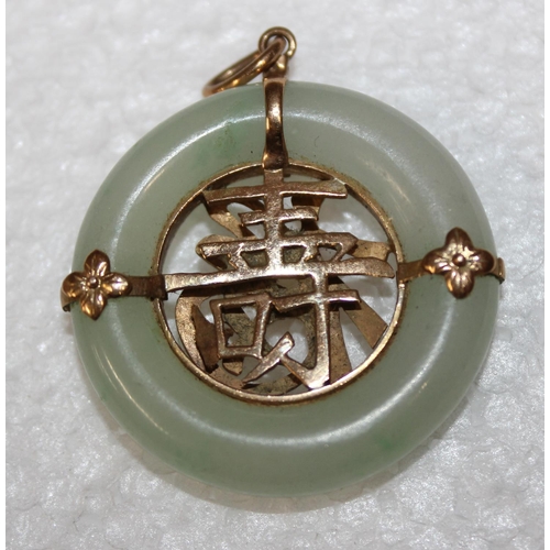 1211 - A Chinese jade and yellow metal mounted pendant, small illegible mark