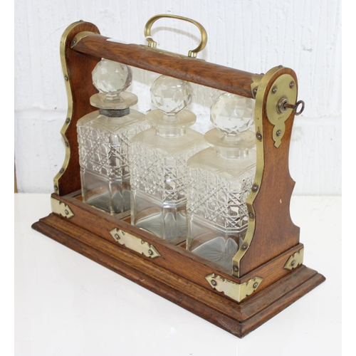 271 - An antique oak cased 3 bottle/ decanter tantalus with key