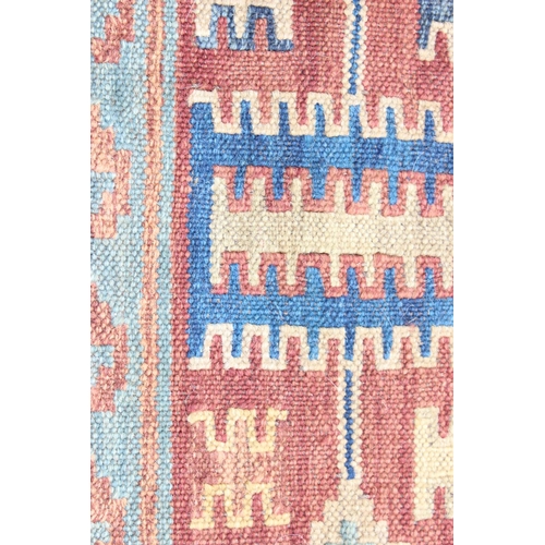 203 - A large golden ground flatweave rug with various red and blue geometric motifs