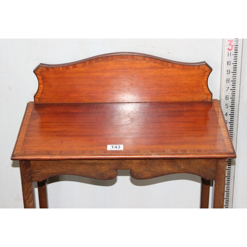 143 - An Edwardian mahogany side table with shaped back