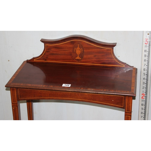 144 - An Edwardian mahogany side table with shaped back and Sheraton type inlay