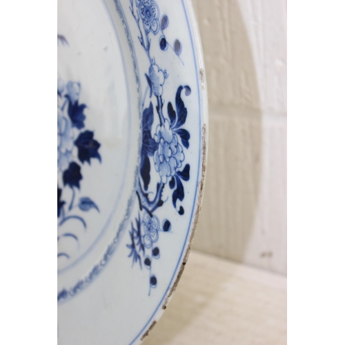 1684 - A large 18th/ 19th century Chinese porcelain charger with blue and white decoration of flowers, appr... 