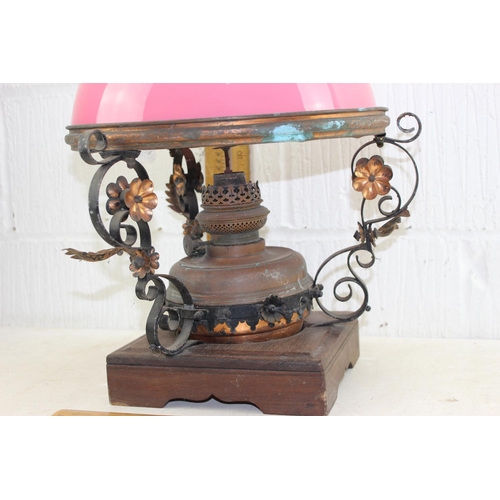 258 - An impressive Victorian wrought iron and brass lamp with later wooden base and pink glass shade