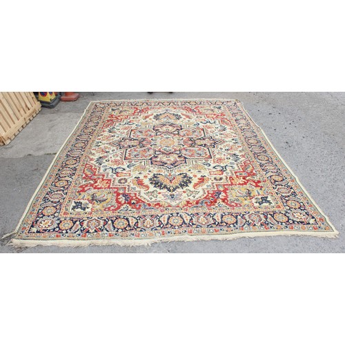 216 - A vintage cream ground rug with various colourful Arabesque motifs and a large central medallion