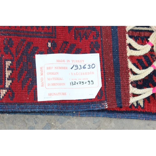 217 - A handmade 20th century Turkish Yagcibedir rug with geometric design, on a red and blue ground, cont... 