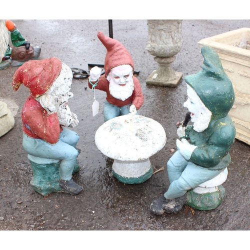 392 - 3 garden gnomes sitting round a toadstool