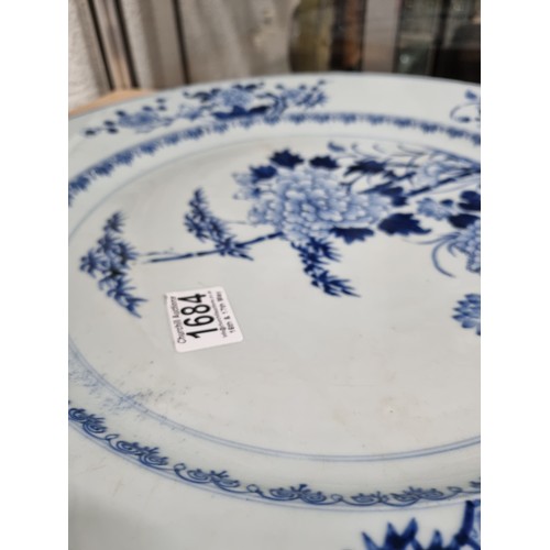 1684 - A large 18th/ 19th century Chinese porcelain charger with blue and white decoration of flowers, appr... 