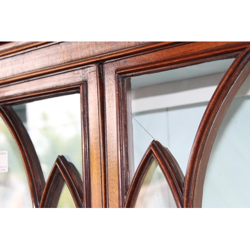 4 - An antique glazed mahogany bookcase with cupboard base